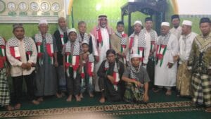 Saripin, berdiri di samping Ulama Palestina dengan kopiah hitam gamis kuning coklat.